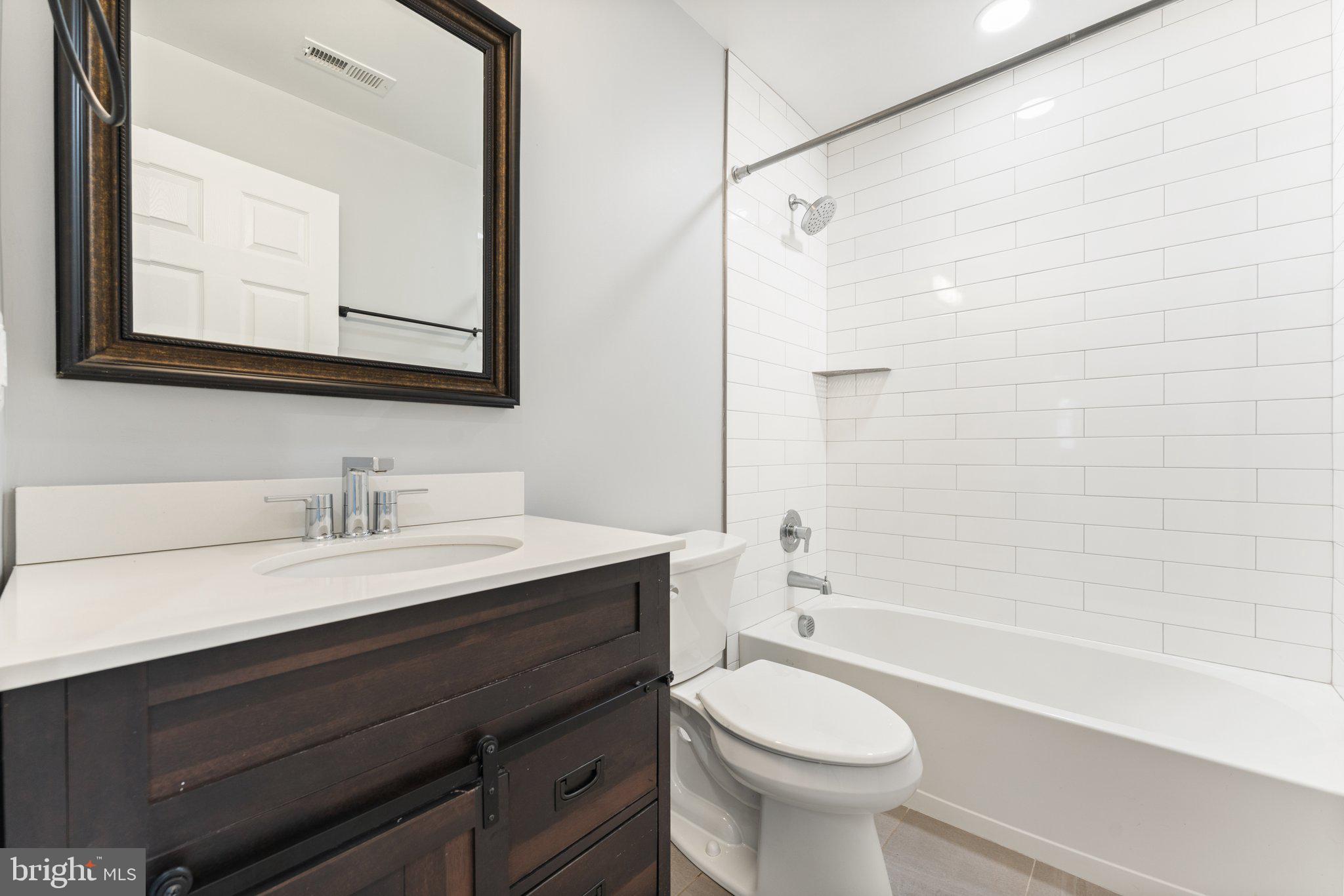 15307 Thoroughfare Road Gainesville, VA 20155 - Photo 28 of 38 a bathroom with a sink a toilet and a mirror