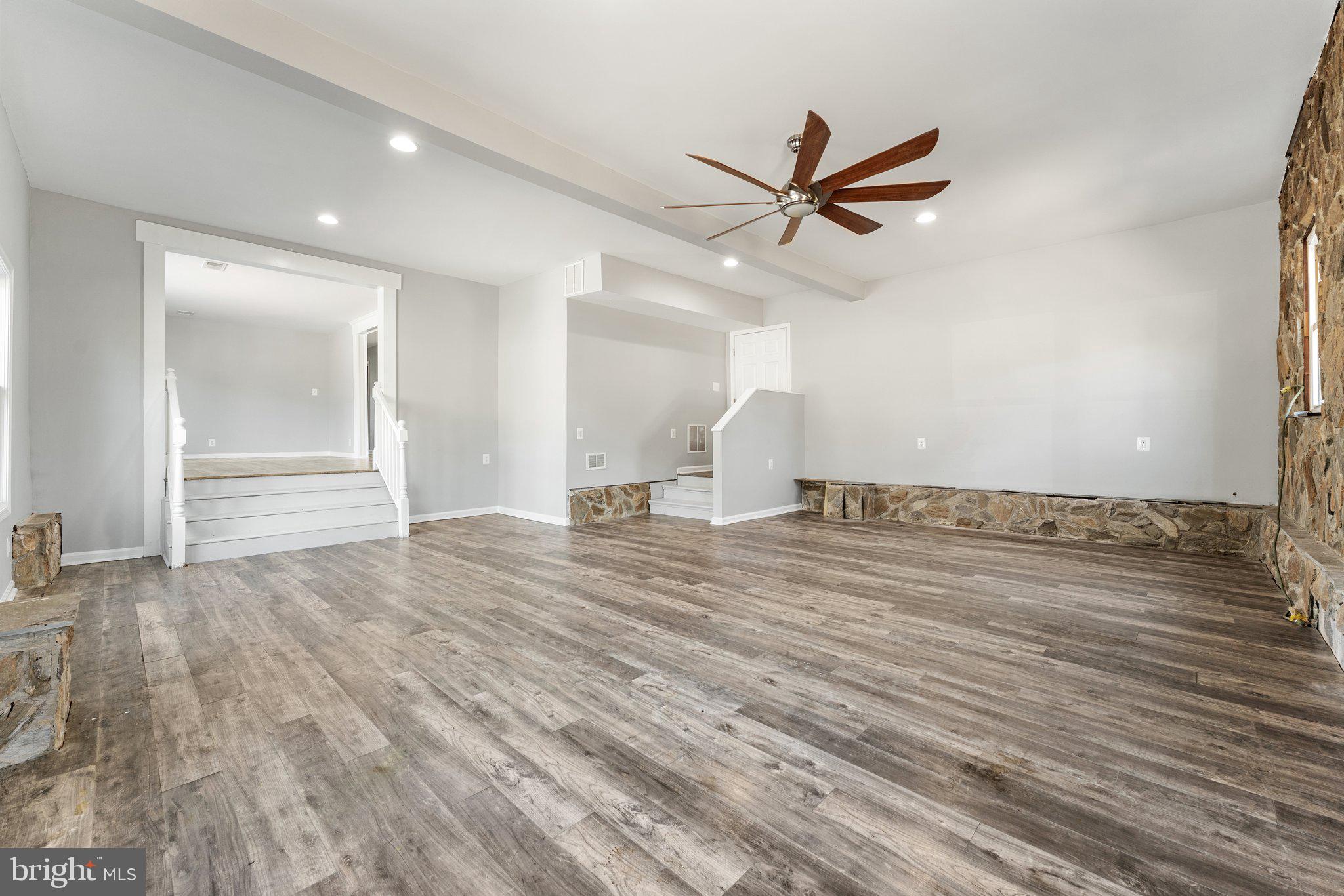 15307 Thoroughfare Road Gainesville, VA 20155 - Photo 30 of 38 an empty room with wooden floor a ceiling fan and windows