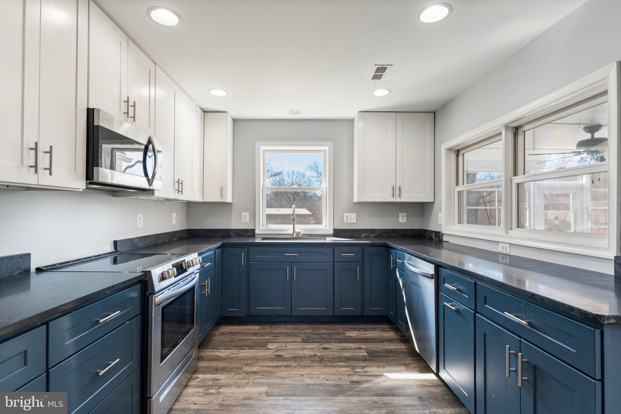 15307 Thoroughfare Road Gainesville, VA 20155 - Photo 8 of 38 a kitchen with stainless steel appliances granite countertop wooden cabinets and a stove top oven