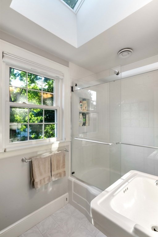 4 Chesterton Road Wellesley, MA 02481 - Photo 20 of 29 a bathroom with a white bath tub sitting next to a window