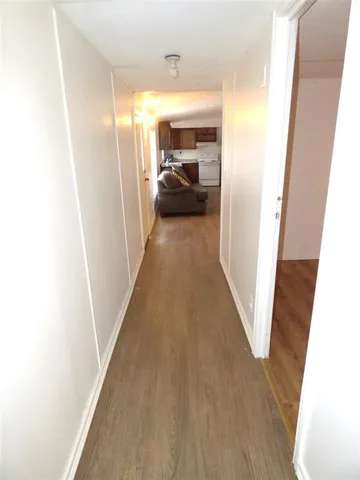 a view of a hallway to a livingroom with furniture