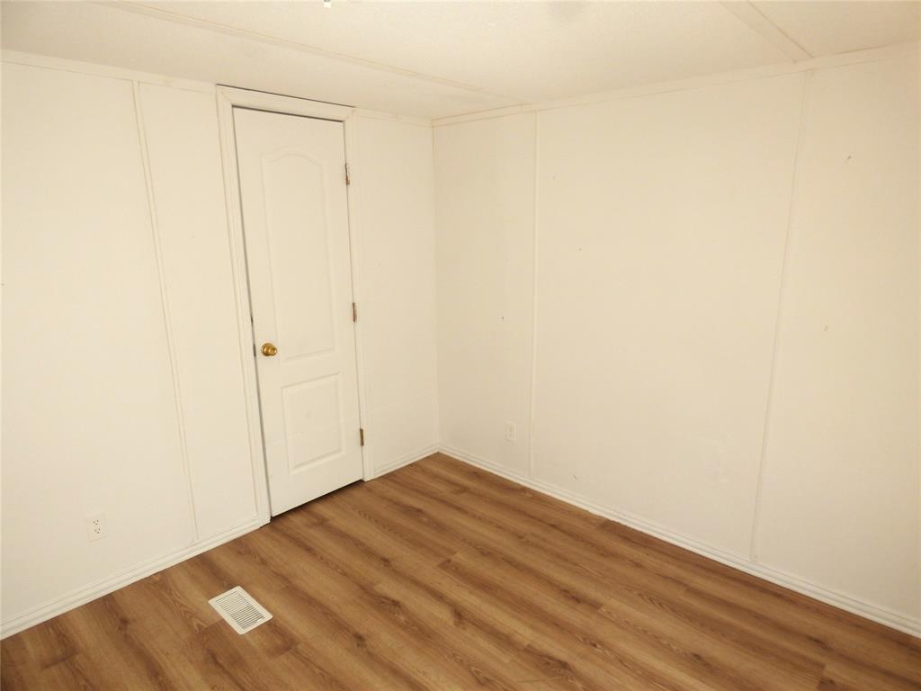 105 East 9th Street Cisco, TX 76437 - Photo 29 of 33 an empty room with wooden floor