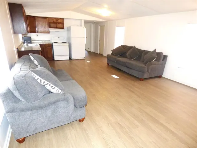 a living room with furniture and kitchen view