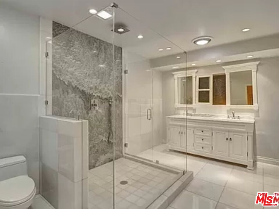 1681 Stone Canyon Road Los Angeles, CA 90077 - Photo 13 of 41 a bathroom with a granite countertop sink mirror and shower