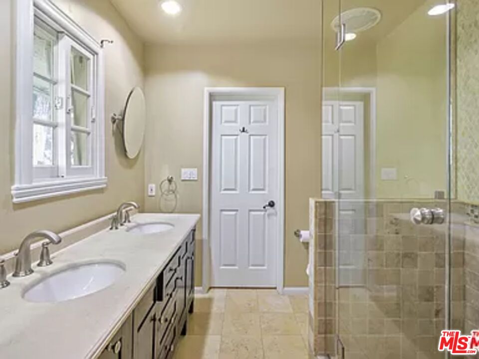 1681 Stone Canyon Road Los Angeles, CA 90077 - Photo 19 of 41 a bathroom with double vanity sinks and a mirror