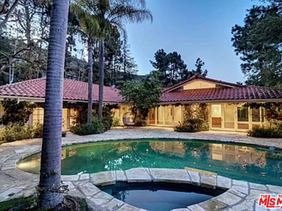1681 Stone Canyon Road Los Angeles, CA 90077 - Photo 21 of 41 a front view of a house with a garden and swimming pool