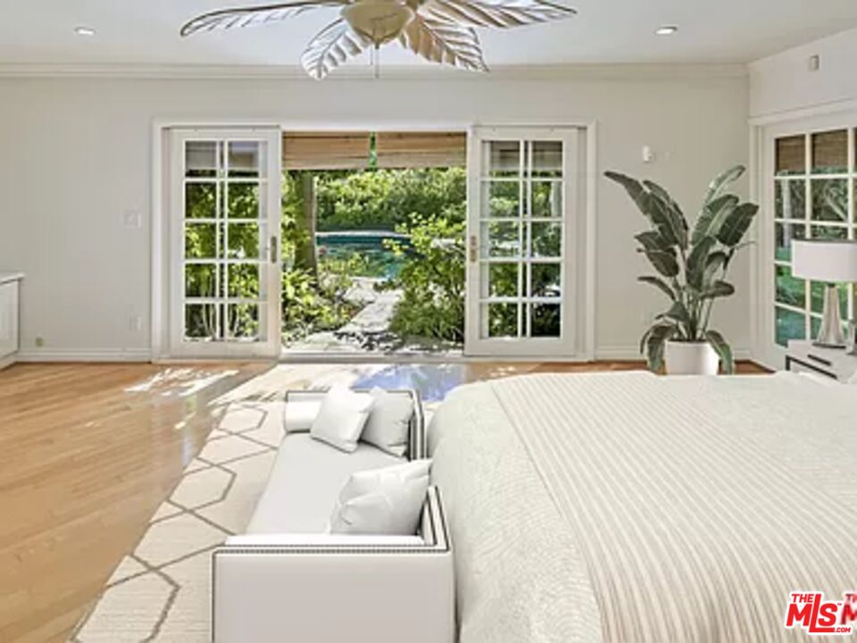 1681 Stone Canyon Road Los Angeles, CA 90077 - Photo 23 of 41 a spacious bedroom with a large bed and a large window