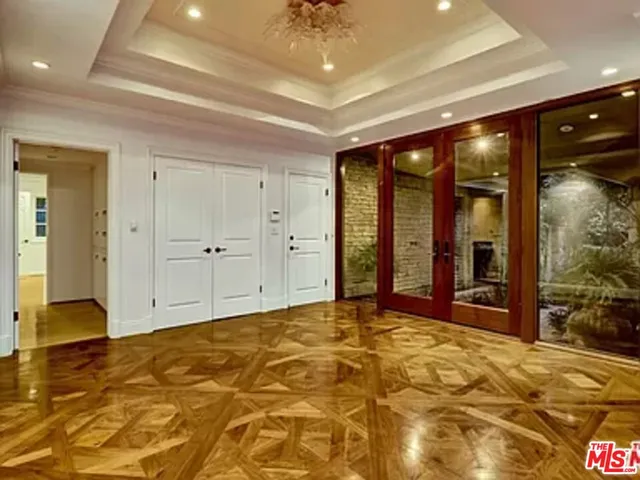a view of an empty room with window and a kitchen