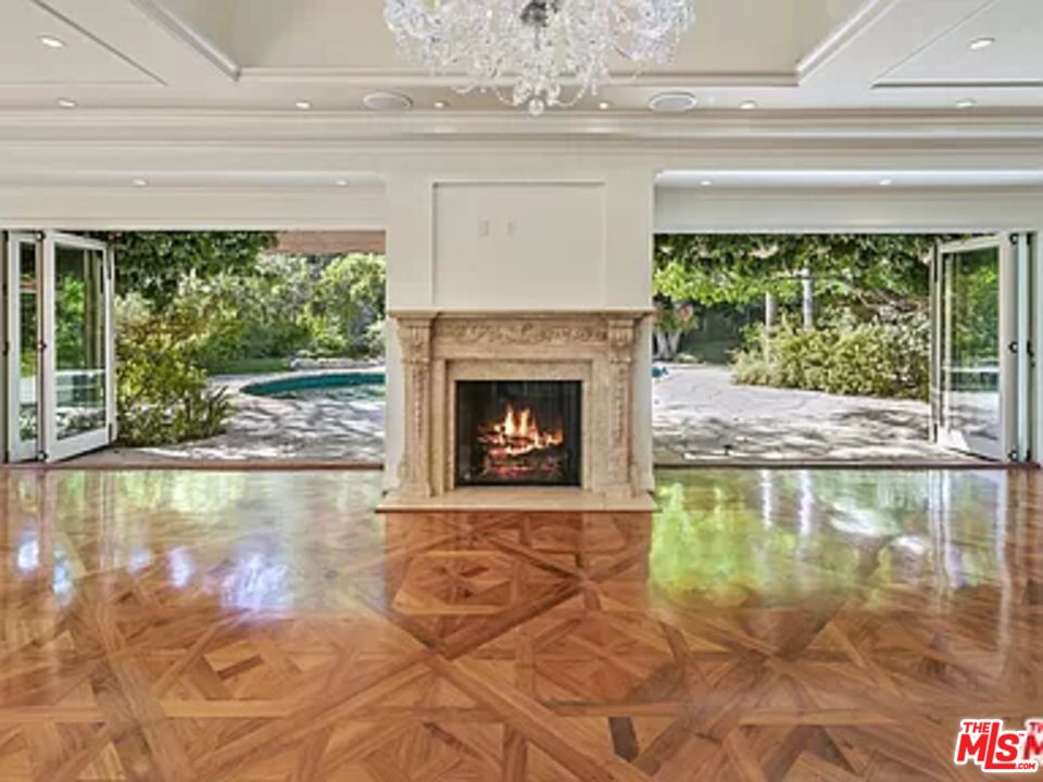 1681 Stone Canyon Road Los Angeles, CA 90077 - Photo 34 of 41 a living room with a fireplace and a floor to ceiling window