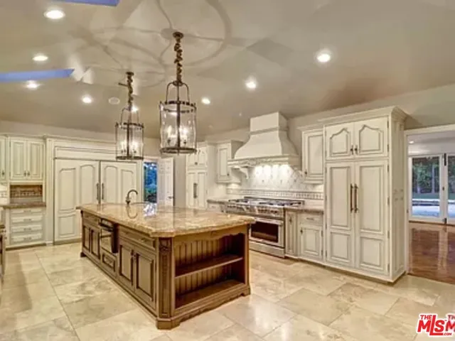 a large kitchen with stainless steel appliances granite countertop a stove and refrigerator