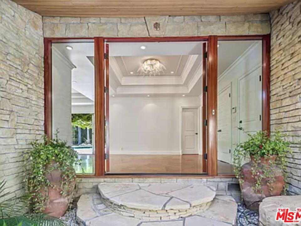 1681 Stone Canyon Road Los Angeles, CA 90077 - Photo 7 of 41 a front view of a house with garden