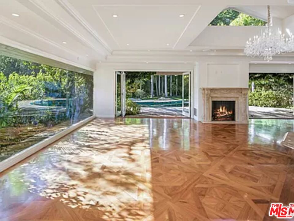 1681 Stone Canyon Road Los Angeles, CA 90077 - Photo 8 of 41 a view of empty room with wooden floor and a floor to ceiling window