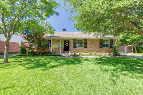 a view of a house with backyard and a tree