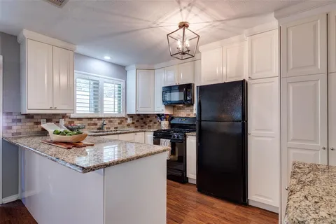 a kitchen with kitchen island granite countertop a refrigerator a sink and dishwasher