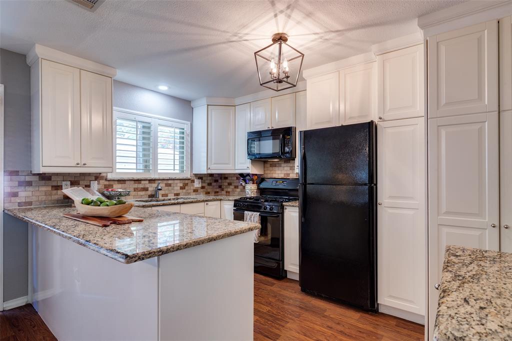 7328 Rockhurst Drive Dallas, TX 75214 - Photo 11 of 22 a kitchen with kitchen island granite countertop a refrigerator a sink and dishwasher