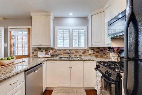 a kitchen with granite countertop a sink stove and cabinets