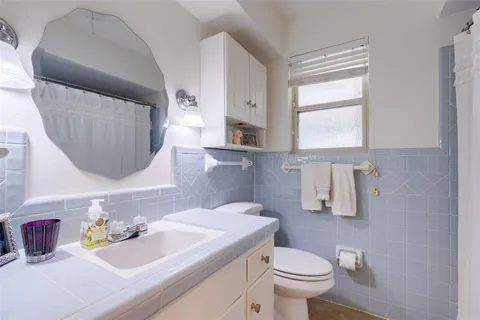 a bathroom with a sink toilet and mirror