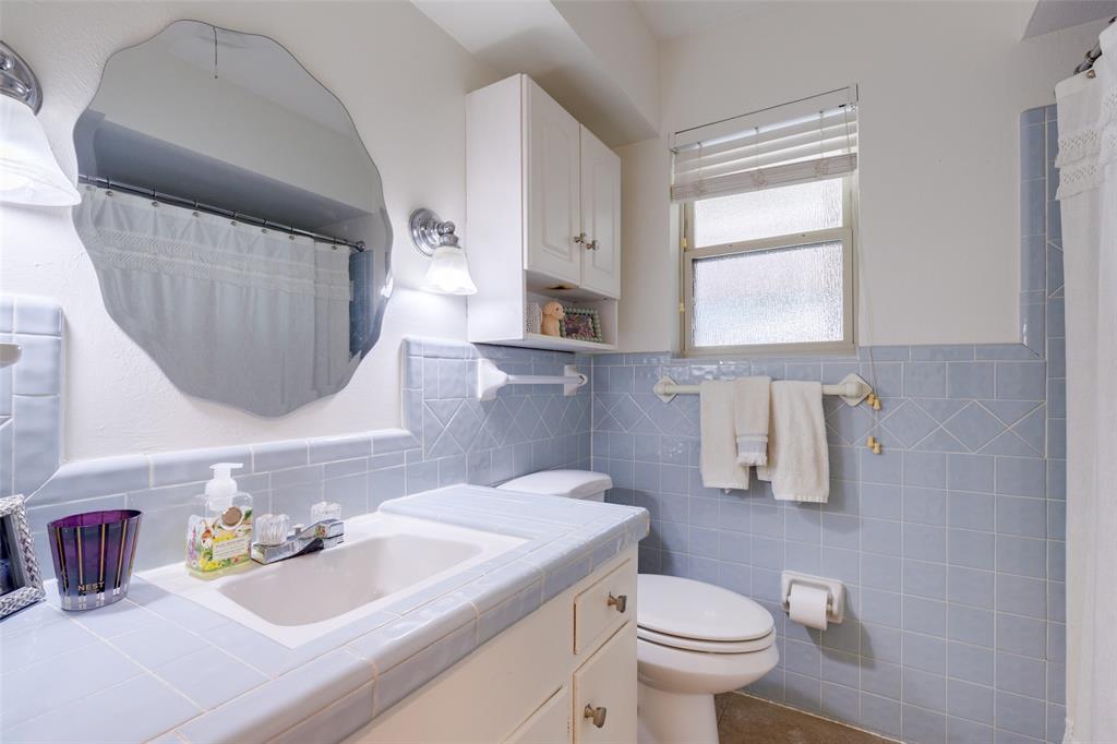 7328 Rockhurst Drive Dallas, TX 75214 - Photo 18 of 22 a bathroom with a sink toilet and mirror