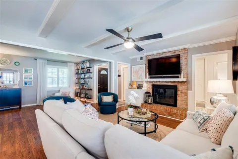 a living room with furniture a fireplace and a flat screen tv