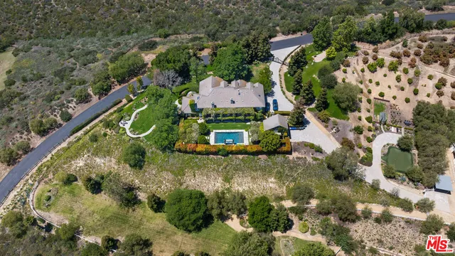 a view of a swimming pool with lawn chairs under an umbrella