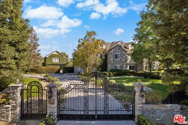 a view of a house with garden and a sitting area