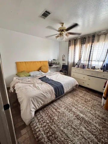 a large bedroom with a bed and wooden floor