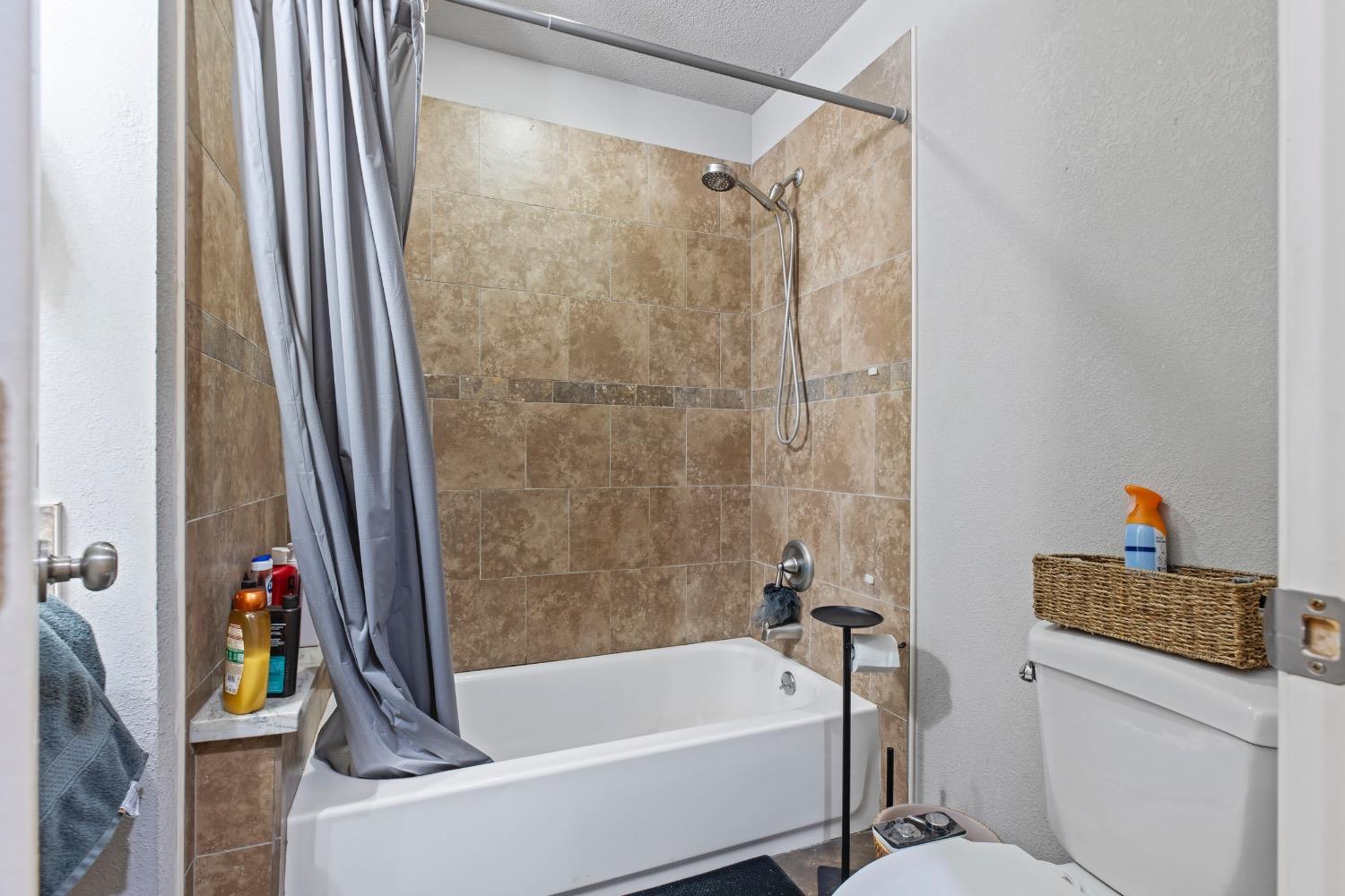 1813 Poppy Lane Ceres, CA 95307 - Photo 12 of 27 a bathroom with a bathtub and a shower
