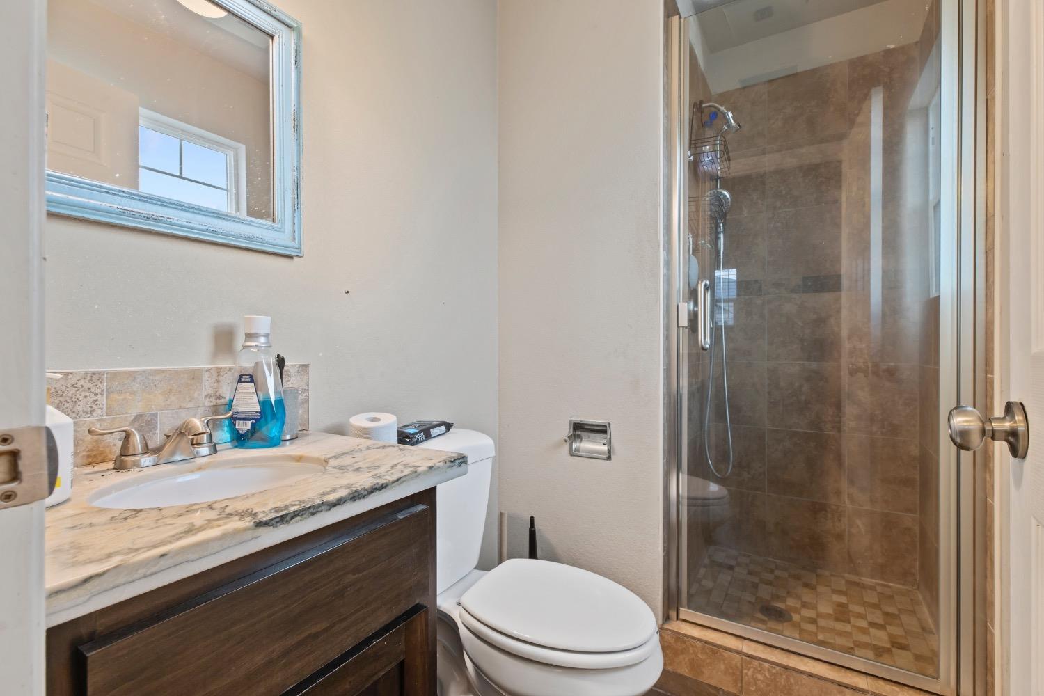 1813 Poppy Lane Ceres, CA 95307 - Photo 17 of 27 a bathroom with a granite countertop sink a toilet a shower and a mirror