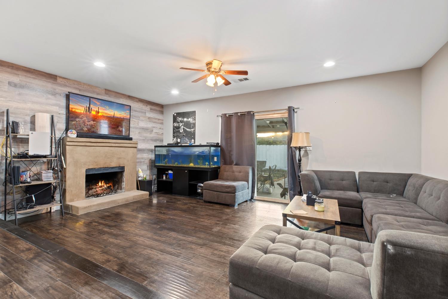 1813 Poppy Lane Ceres, CA 95307 - Photo 5 of 27 a living room with furniture a fireplace and a flat screen tv