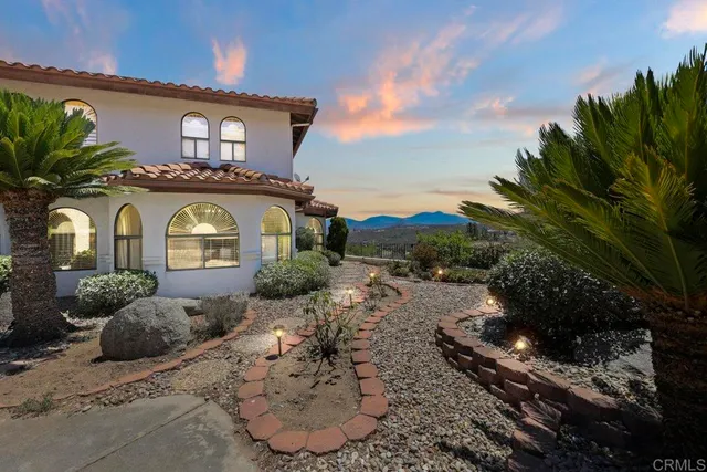 a view of a house with a yard and potted plants