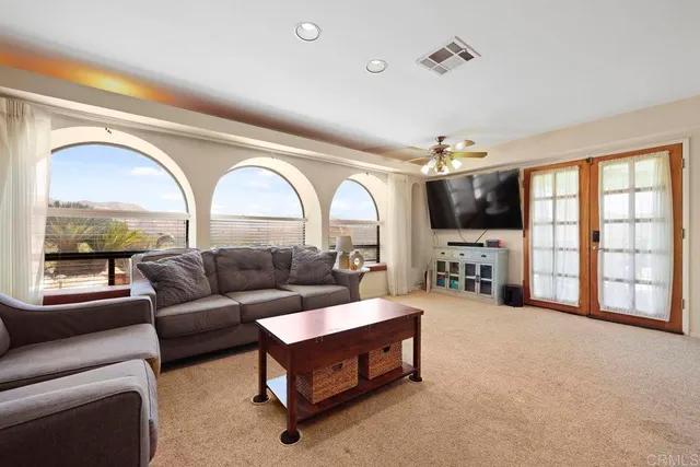 a living room with furniture a wooden floor and a large window