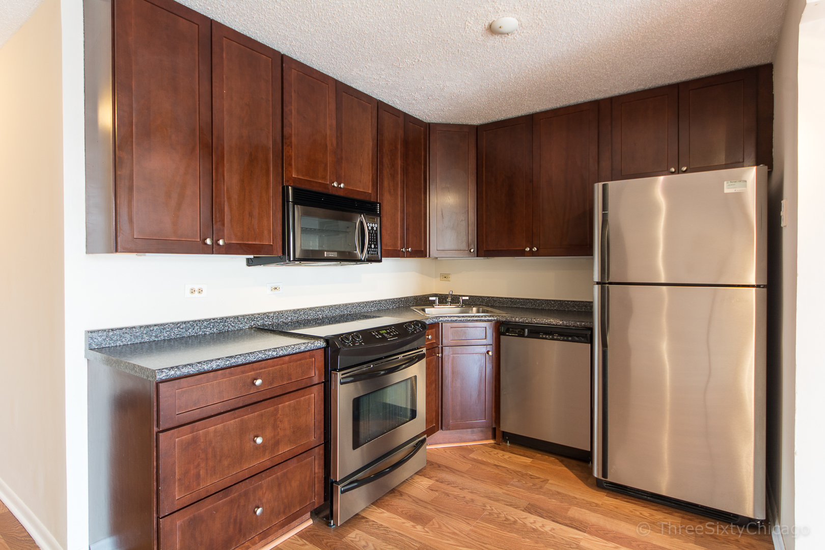 111 West Maple Street, Unit 2406 Chicago, IL 60610 - Photo 4 of 18 a kitchen with a refrigerator stove and microwave