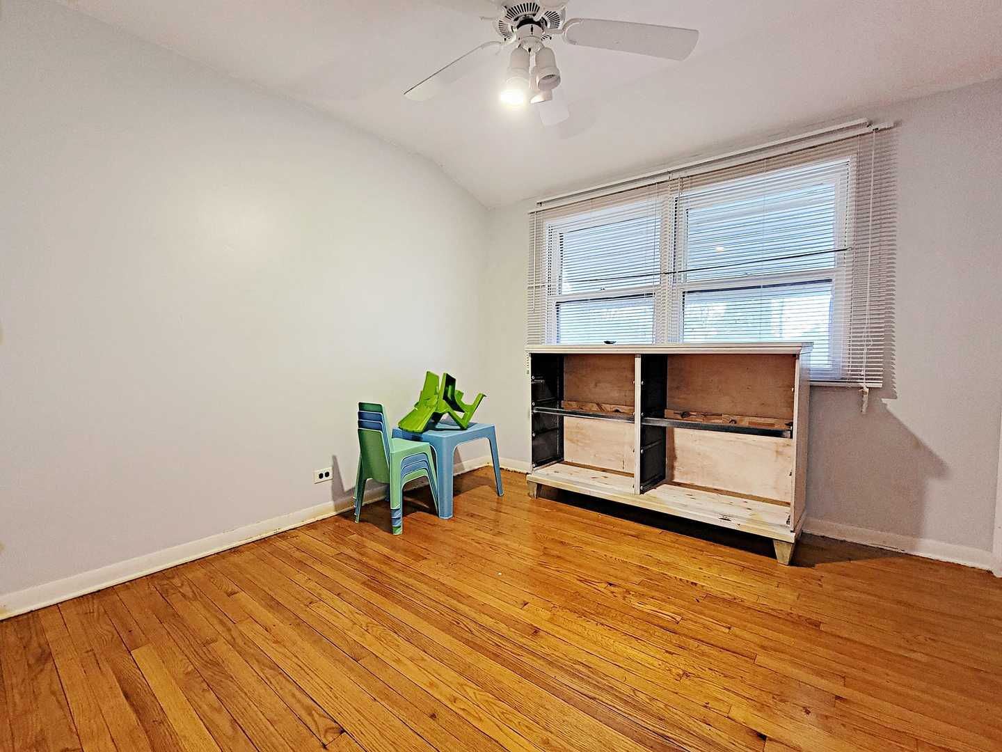Undisclosed Address Dolton, IL 60419 - Photo 7 of 9 a view of an empty room with a window and wooden floor