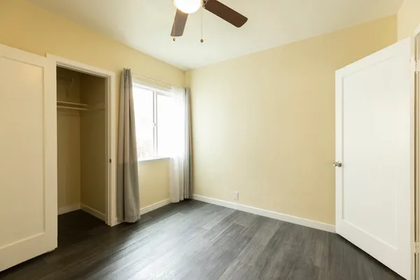 an empty room with wooden floor and window