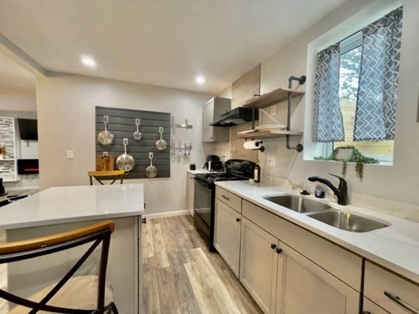 a kitchen with sink a microwave and cabinets