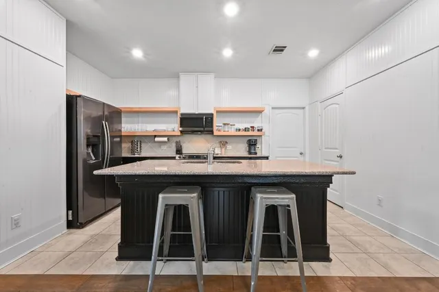 a kitchen with stainless steel appliances granite countertop a stove a sink and a refrigerator