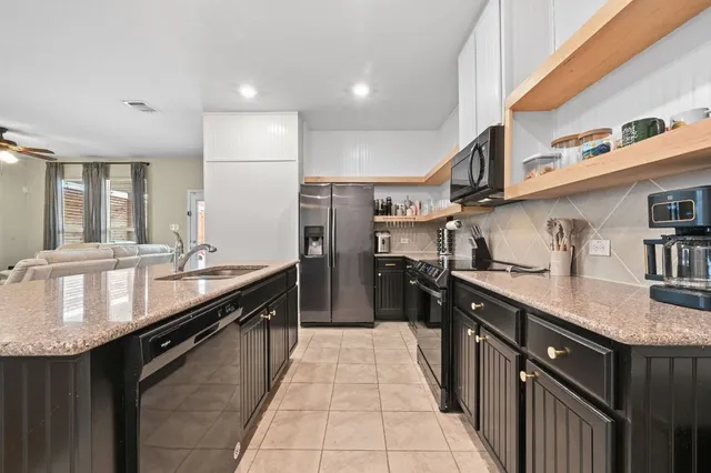a large kitchen with stainless steel appliances granite countertop a sink stove and cabinets