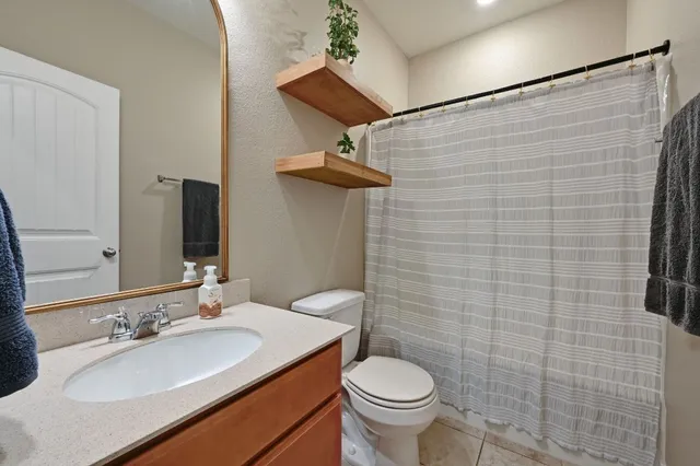 a bathroom with a granite countertop toilet sink and mirror