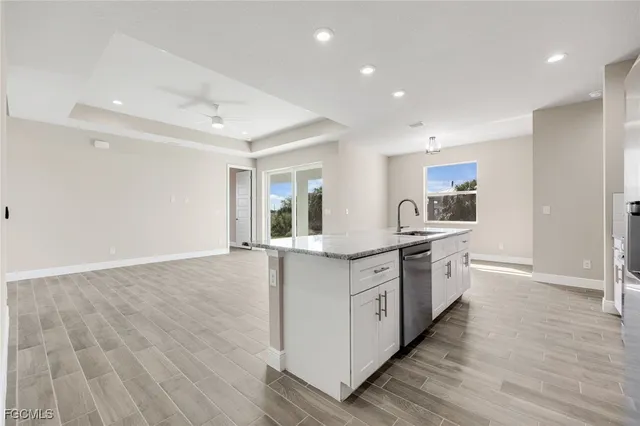 a large kitchen with granite countertop a large counter top space stainless steel appliances and cabinets