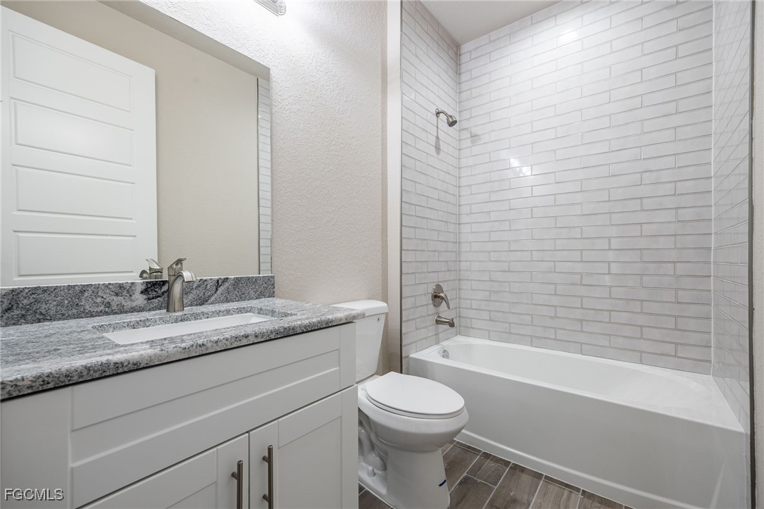 1346 Radio Loop LaBelle, FL 33935 - Photo 17 of 27 a bathroom with a granite countertop bathtub shower sink vanity and toilet