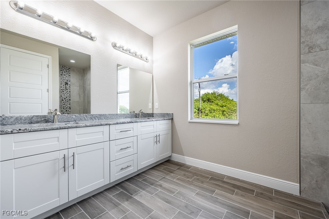 1346 Radio Loop LaBelle, FL 33935 - Photo 23 of 27 a bathroom with a granite countertop sink and a mirror