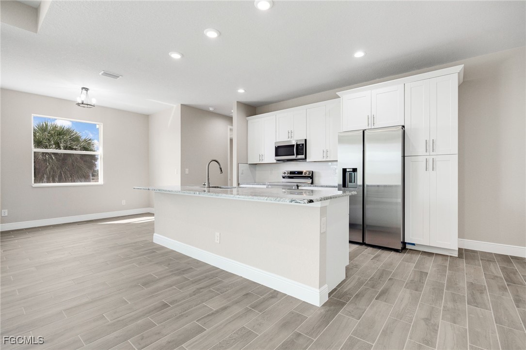1346 Radio Loop LaBelle, FL 33935 - Photo 10 of 27 a kitchen with refrigerator cabinets and wooden floor