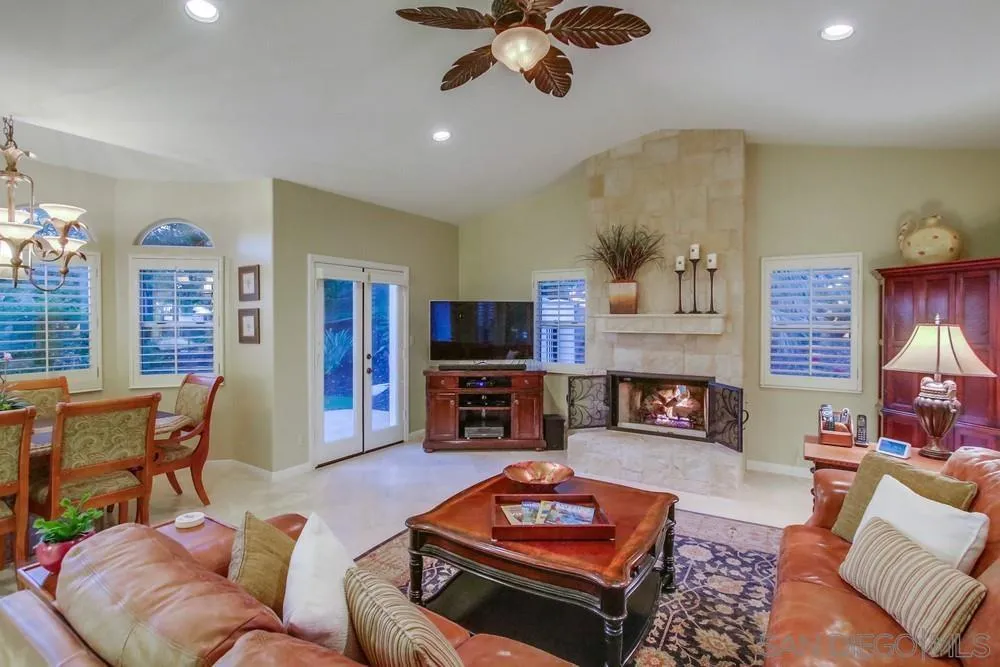 14399 Blue Sage Road Poway, CA 92064 - Photo 22 of 70 a living room with furniture a fireplace and a chandelier