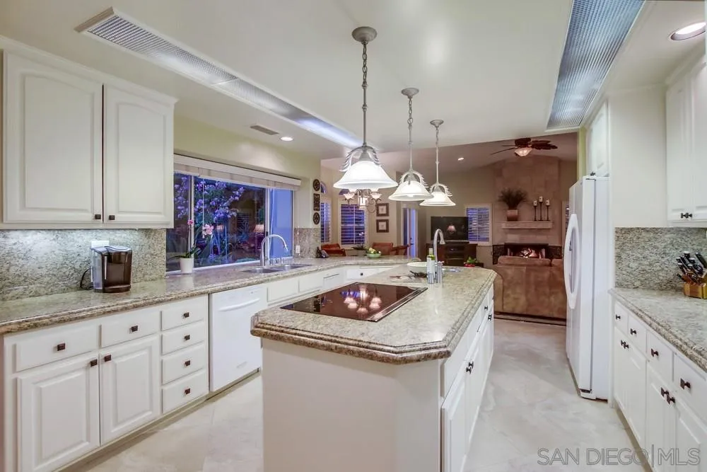 14399 Blue Sage Road Poway, CA 92064 - Photo 29 of 70 a kitchen with granite countertop a sink a stove top oven and cabinets