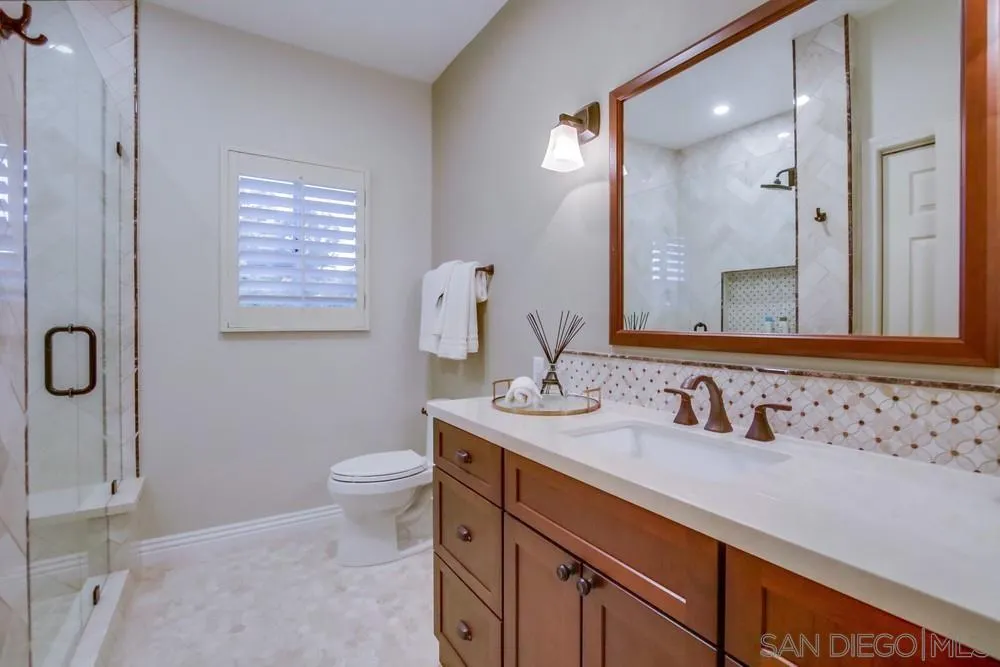 14399 Blue Sage Road Poway, CA 92064 - Photo 44 of 70 a bathroom with a sink a toilet a mirror and shower