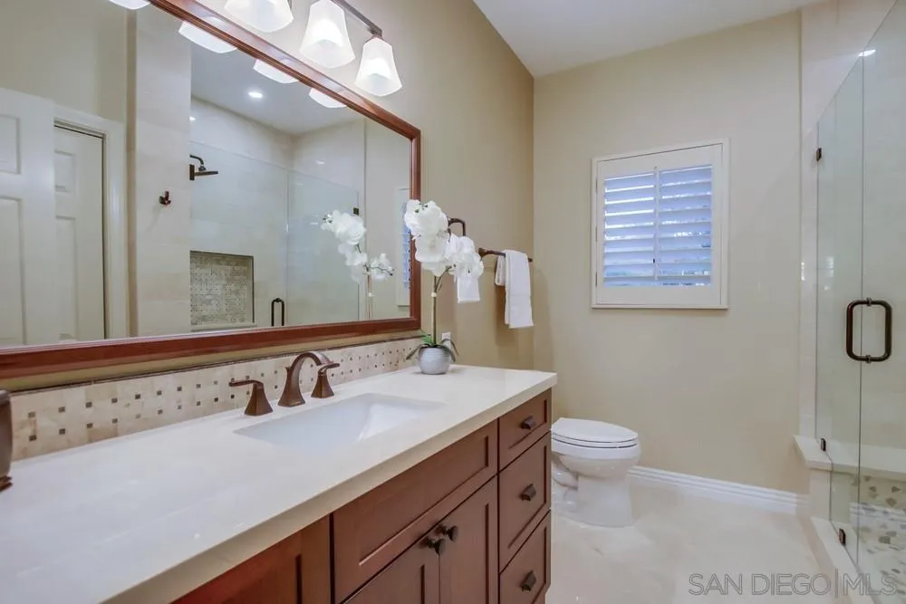 14399 Blue Sage Road Poway, CA 92064 - Photo 47 of 70 a bathroom with a granite countertop sink a toilet and a mirror