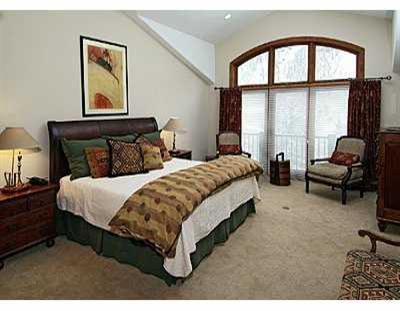 2350 Bald Mountain Road, Unit 3 Vail, CO 81657 - Photo 5 of 8 a bedroom with a bed a table and large mirror next to a window