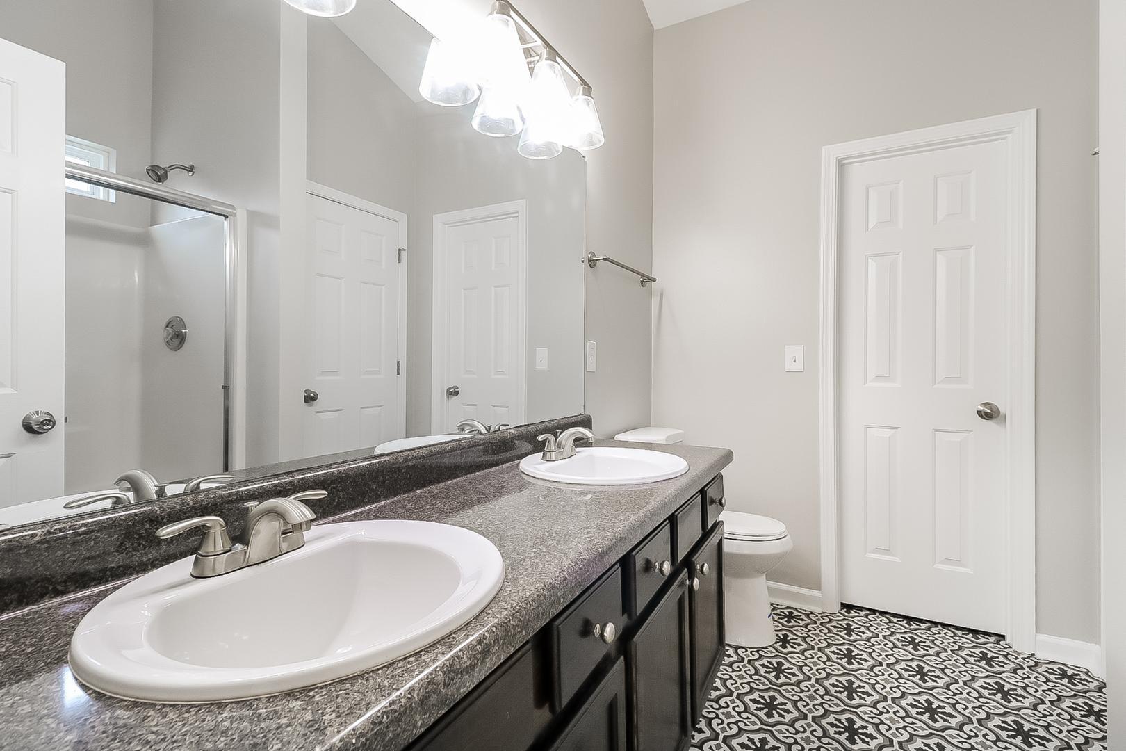 5900 Wessel Way Raleigh, NC 27610 - Photo 13 of 17 a bathroom with a double vanity sink and a mirror