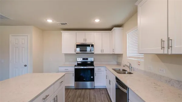 a kitchen with a sink stove top oven and cabinets