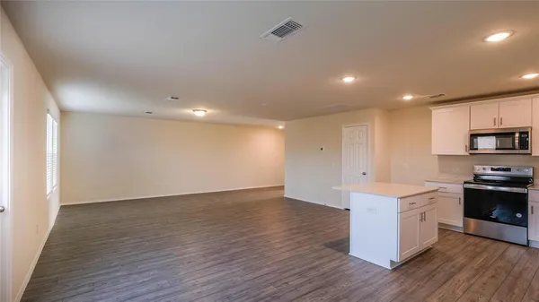 a view of kitchen with stainless steel appliances granite countertop cabinets wooden floor and a sink
